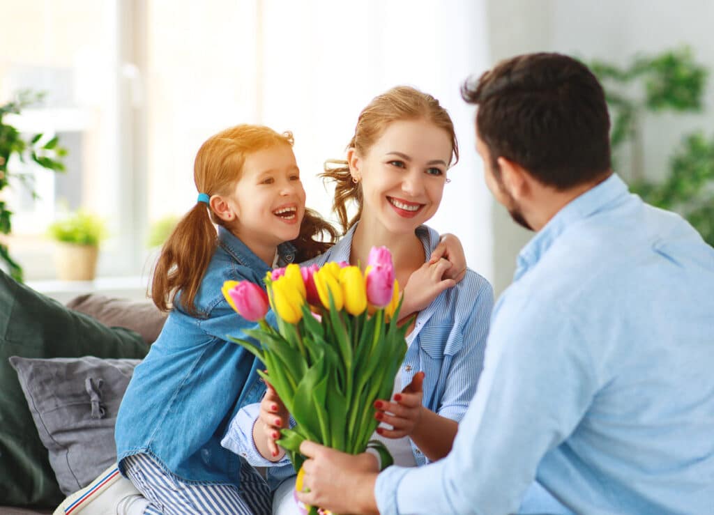 A husband Giving Tulips as a gift to his wife and child
