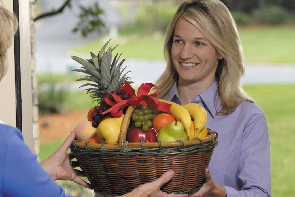 A Woman gifting Fruits Basket