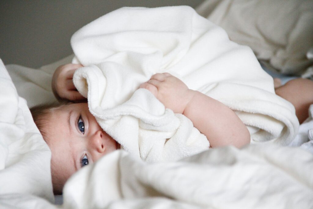 New Born Baby Holding White Blanket