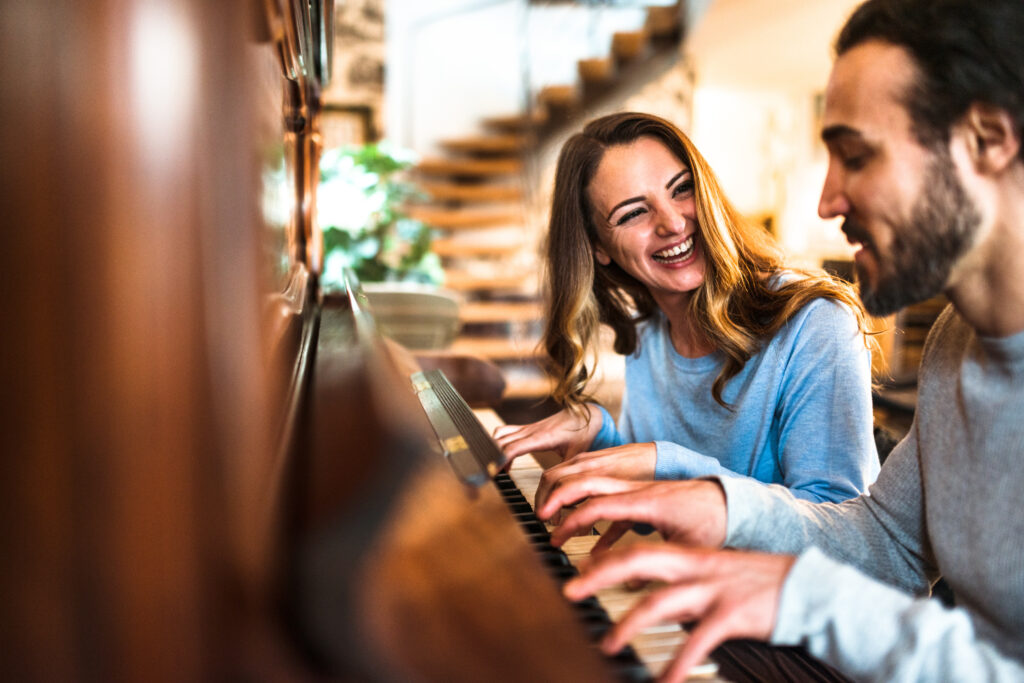 Couple learning to play piano together
