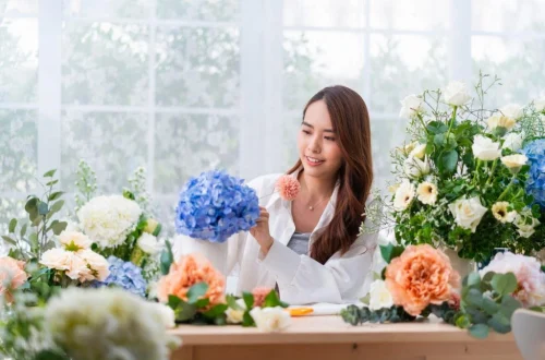 A Girl looking at Flowers on a Table