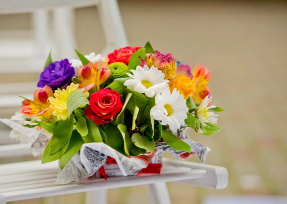 A vibrant bouquet of flowers adorns a white chair, showcasing the latest flower trends in Dubai.