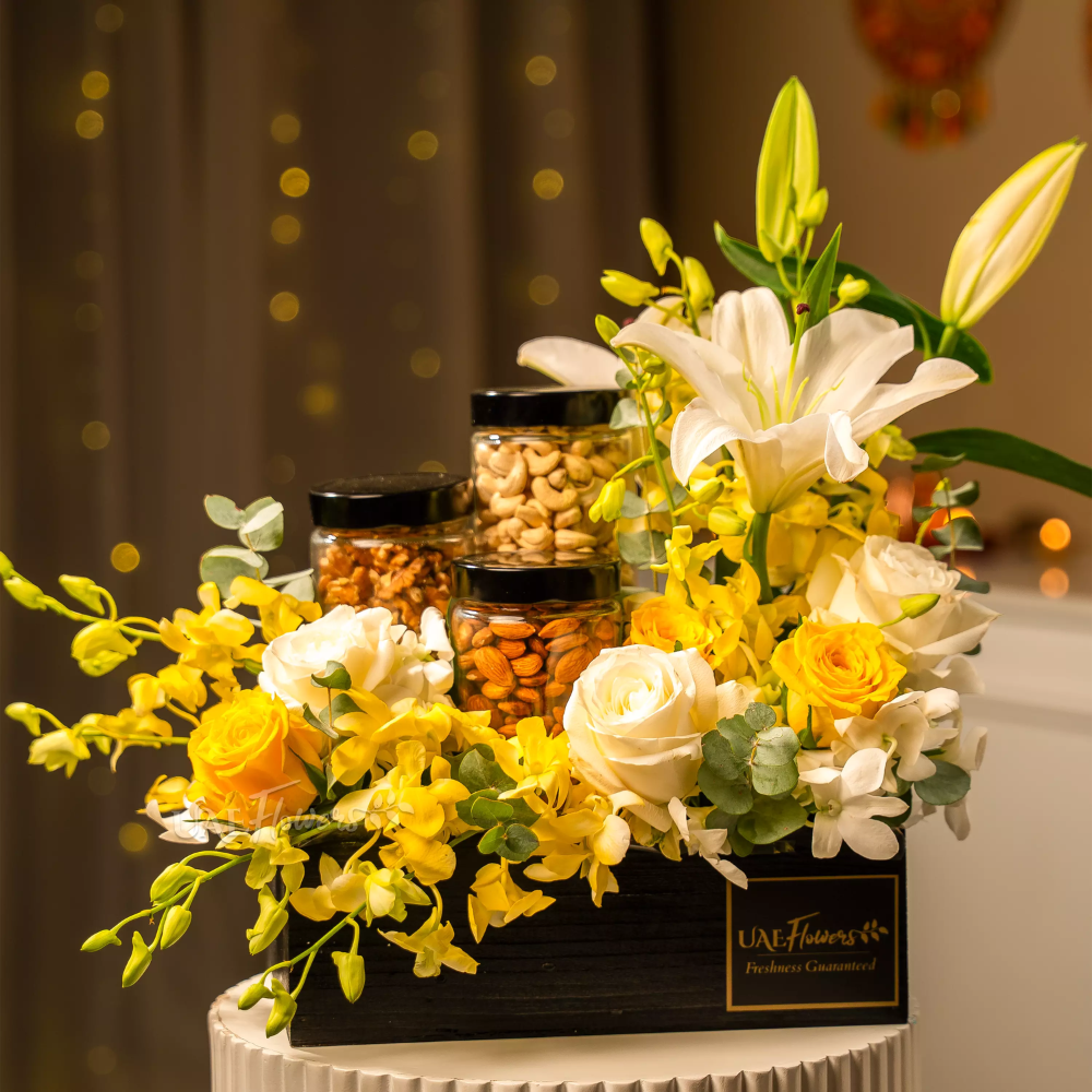 Diwali Gifts Ideas for Friends featuring an elegant flower arrangement with white lilies, yellow roses, and premium dry fruit jars in a luxury black box.