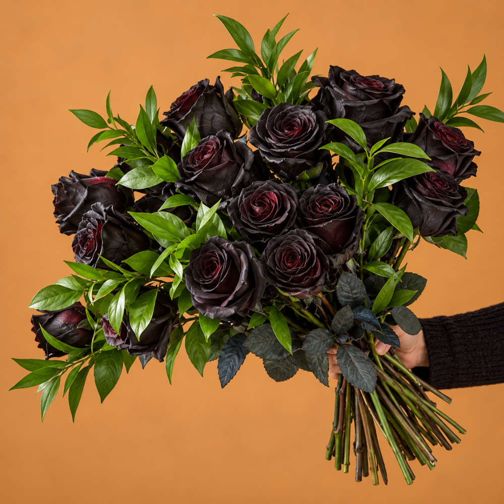 Halloween Flower Gift featuring a bouquet of elegant black roses, fresh green foliage, and long stems against an orange background.